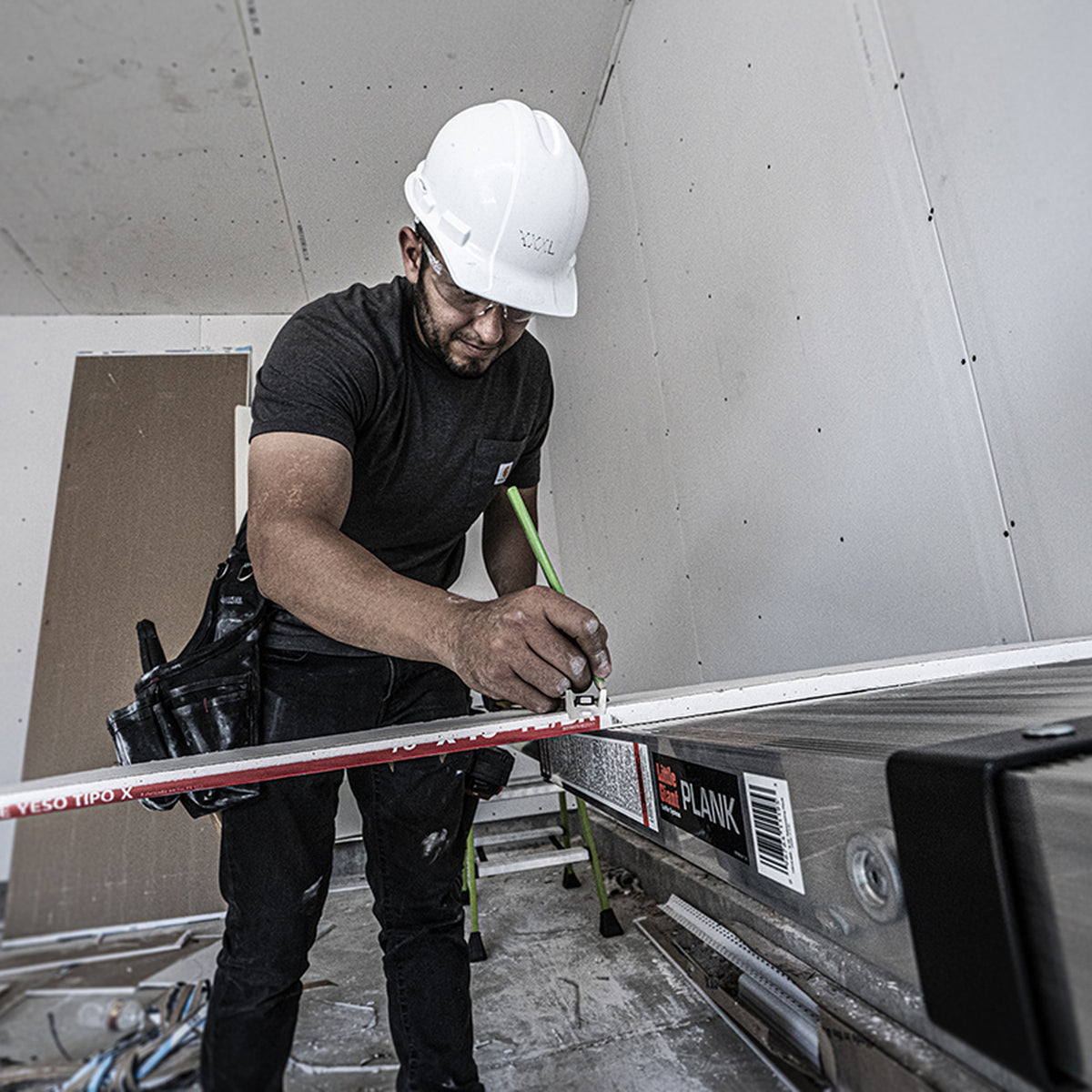 Handwerker arbeitet vom 2-Person Plank aus an der Wand